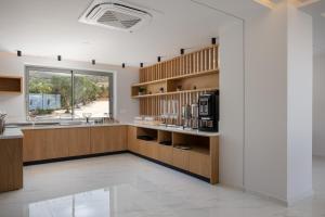 a kitchen with wooden cabinets and a large window at Falasarna Bay Hotel in Falasarna