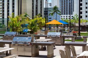 an outdoor patio with tables and chairs and umbrellas at Ocean view high-floor condo with lanai & beach access in Honolulu +54 photos