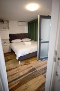 a small bedroom with a bed and a green curtain at Leona in Kamešnica