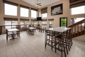 a dining room with tables and chairs and windows at Super 8 by Wyndham Longmont/Twin Peaks in Longmont