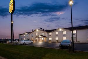 a building with cars parked in a parking lot at night at Super 8 by Wyndham Perham in Perham