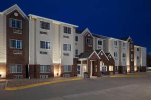 a row of apartment buildings at night at Microtel Inn & Suites - Kearney in Kearney