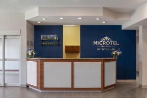 a lobby with a muedel sign on a wall at Microtel Inn & Suites - Kearney in Kearney