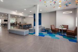 a waiting room with chairs and tables and a ceiling with butterflies at Microtel Inn & Suites - Kearney in Kearney