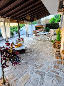 a patio with a couch and chairs on a stone floor at Joanna Studio in Akamatra