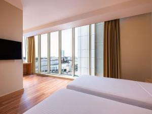 a bedroom with a bed and a large window at Ibis Riyadh Hotel Al Muhammadiyah United Company Branch in Riyadh +55 photos