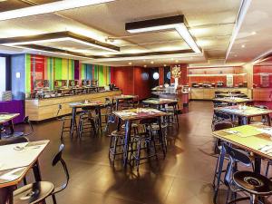 a dining room with tables and chairs in a restaurant at ibis Styles Chiang Mai in Chiang Mai +77 photos