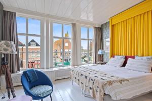 a bedroom with a large bed and a blue chair at Gentle in Bolsward