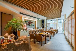 a restaurant with wooden ceilings and tables and chairs at Pan Pacific Ningbo in Ningbo