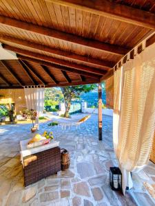 an outdoor patio with a couch and a wooden roof at Joanna Studio in Akamatra