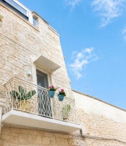 a balcony with potted plants on a building at Casa De Amicis 24 in Sammichele di Bari