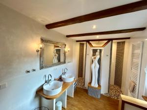 a bathroom with two sinks and a mannequin in a mirror at Fachwerkliebe Villa Mia in Olsberg +46 photos