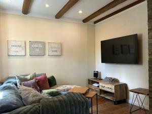 a living room with a couch and a flat screen tv at Fachwerkliebe Villa Mia in Olsberg