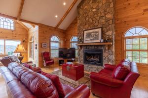 a living room with leather furniture and a stone fireplace at Buena Vista in Todd