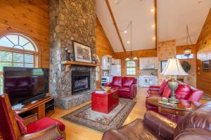 a living room with red furniture and a stone fireplace at Buena Vista in Todd