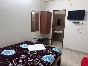 a room with a bed and a bathroom with a sink at SAARA INN in Pondicherry
