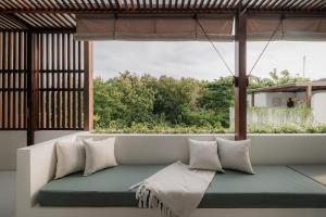 a couch in a room with a large window at Suasana by AYA in Uluwatu