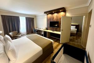 a hotel room with a large bed and a desk at Dazzler by Wyndham Buenos Aires San Martin in Buenos Aires