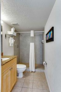 a bathroom with a toilet and a sink and a shower at Surf Beach Resort by Sunsational Beach Rentals in St Pete Beach