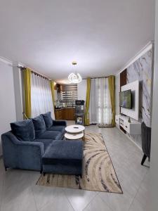a living room with a blue couch and a table at Supreme Apartments in Kansiri