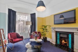 a living room with a fireplace and a tv at Hotel Harry, an Ascend Collection Hotel in Sydney