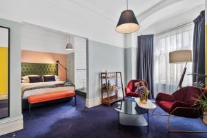 a hotel room with a bed and two chairs at Hotel Harry, an Ascend Collection Hotel in Sydney