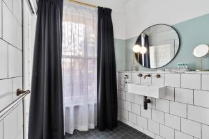 a bathroom with a shower curtain and a sink at Hotel Harry, an Ascend Collection Hotel in Sydney +31 photos