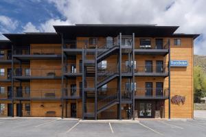 an apartment building with a spiral staircase in a parking lot at Travelodge by Wyndham Gardiner Yellowstone Park North Entr in Gardiner