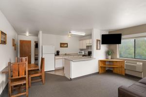 a living room with a kitchen and a dining room at Travelodge by Wyndham Gardiner Yellowstone Park North Entr in Gardiner
