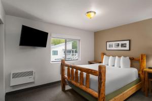 a bedroom with a bed and a window at Travelodge by Wyndham Gardiner Yellowstone Park North Entr in Gardiner