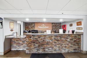 a lobby with a stone counter with a brick wall at AmericInn by Wyndham White Bear Lake St. Paul in White Bear Lake