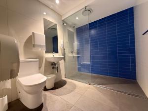 a bathroom with a toilet and a blue tile wall at Global Backpackers Youth Hostel in Cairns +67 photos