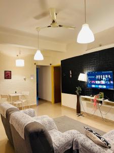 a living room with a couch and a flat screen tv at Electrifying Pearl in Bangalore