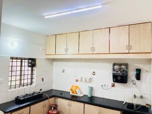 a kitchen with wooden cabinets and a black counter top at Electrifying Pearl in Bangalore