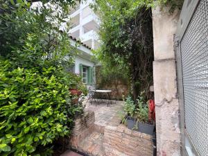 a garden with a table and some plants and a building at Orpheus Guesthouse in Athens