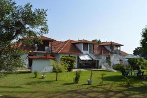 a large house with a yard with a table and chairs at Thea apartments 2 in Platamonas