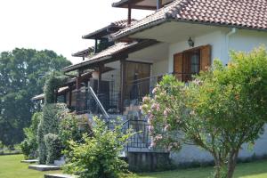 a house with a balcony and some bushes at Thea apartments 2 in Platamonas +9 photos