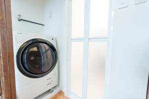 a washing machine in a room next to a window at Imafuku Happiness Villa in Osaka