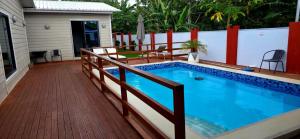 ein Swimmingpool mit Holzdeck und Zaun in der Unterkunft Sunset Villas in Korotogo