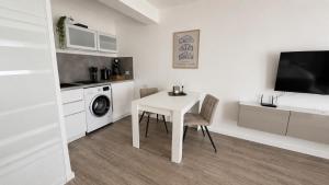 a white table and chair in a white room at Ferienwohnung an der Steinmauer in Bad Kissingen