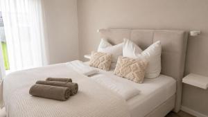 a white bed with two towels on top of it at Ferienwohnung an der Steinmauer in Bad Kissingen