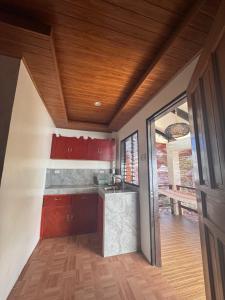 a kitchen with red cabinets and a wooden ceiling at Latitude 10 Siargao in General Luna +40 photos