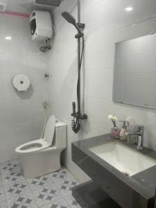 a bathroom with a toilet and a sink and a mirror at Bich Gian Trang An Hostel in Nguyên Ngoại