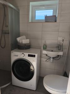ein Badezimmer mit Waschmaschine und Toilette in der Unterkunft Vabadus in Kärdla