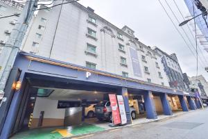 a large white building with a parking garage at Jamsil Tomgi Hotel in Seoul