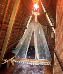 a bedroom in a tree house with a mosquito net at Firefly Treehouse Cafe and Bar in Ytaya