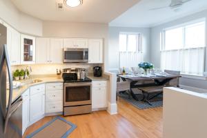 a kitchen with white cabinets and a table with a dining room at The Newport Lofts - 194 Thames Street in Newport