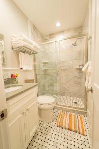 a white bathroom with a shower and a toilet at The Newport Lofts - 194 Thames Street in Newport