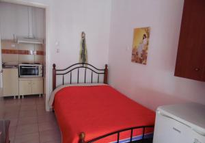 a small room with a red bed in a kitchen at Four Seasons 1 in Paralia Katerinis
