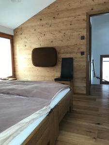 a bedroom with a bed with a wooden wall at Ferienwohnung Ursis Stall in Münster